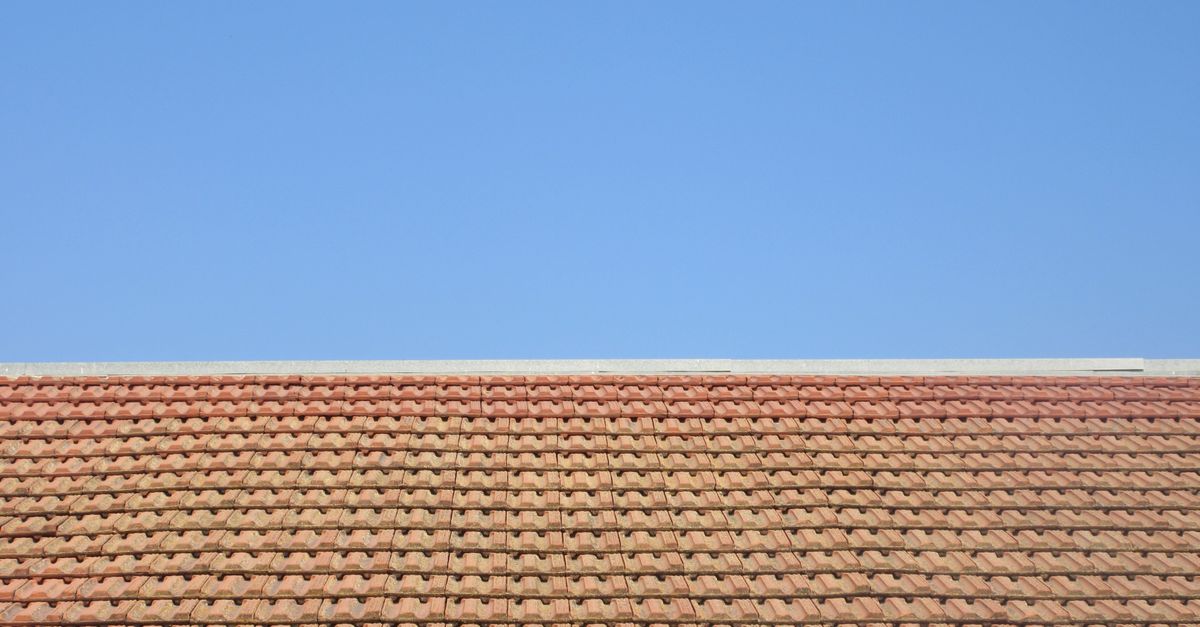 Naravno rdeča keramična strešna površina pod modrim nebom